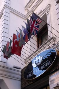 ein Schild für ein Hotel mit Flaggen an einem Gebäude in der Unterkunft Felicity Hotel İstanbul in Istanbul