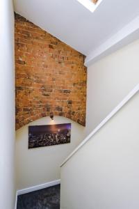 a brick wall in a hallway with a picture on the wall at LARGE DUPLEX Apartment in CITY CENTRE! LIME STREET! FOOTBALL! Ideal for Stag and Hen Do Stays! in Liverpool