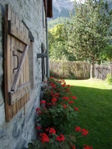 a building with a window with flowers on the side at Chalet familial de village en Savoie in Peisey-Nancroix