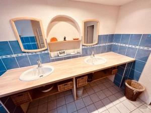 a bathroom with two sinks and two mirrors at Chalet familial de village en Savoie in Peisey-Nancroix
