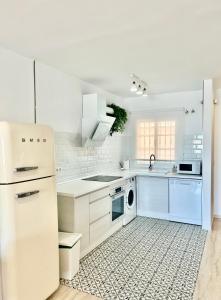 cocina blanca con nevera y lavavajillas en Apartamentos Pacifico, en Nerja