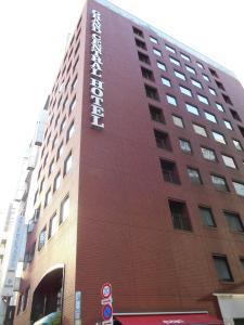 a tall building with a sign on the side of it at Grand Central Hotel in Tokyo