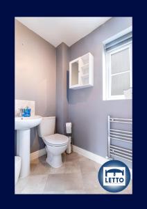 a bathroom with a white toilet and a sink at Letto Serviced Accommodation Peterborough - Davis House - PE7 - FREE Parking in Peterborough
