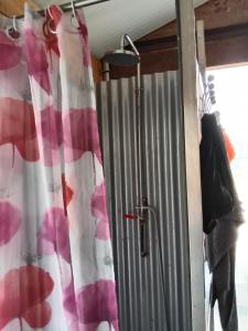 une douche avec rideau de douche rouge et blanc dans l'établissement Un tonneau à la belle étoile, à Irancy