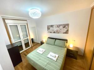 um quarto com uma cama verde com duas almofadas em RELAX VIVEIRO em Viveiro