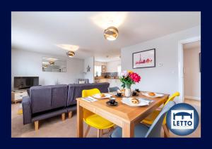 a dining room and living room with a table and chairs at Letto Serviced Accommodation Peterborough - Davis House - PE7 - FREE Parking in Peterborough