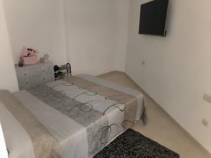a bedroom with a bed with a gray blanket at turisblo apartamento 2 in Benicarló