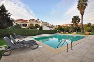 - une piscine avec 2 chaises longues à côté d'une maison dans l'établissement Porto Concept Home - University Residence & Guesthouse - Pólo II Areosa, à Porto