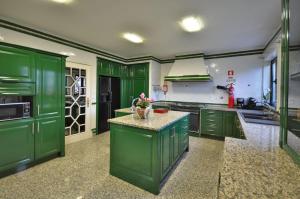 eine grüne Küche mit grünen Schränken und einer Theke in der Unterkunft Porto Concept Home - University Residence & Guesthouse - Pólo II Areosa in Porto