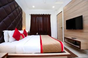 a bedroom with a large bed and a flat screen tv at Hotel King's way in Amritsar