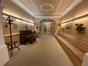 an empty hallway with a piano in a building at Green Gables Hotel in Scarborough