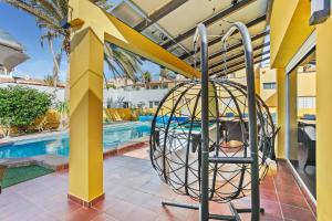 a ball in a cage next to a swimming pool at Villa Mariposas in Corralejo