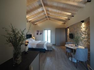 a hotel room with a bed and a table at Terra Di Pietra Exclusive Suites & Apartments in Areopolis