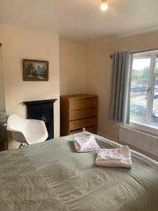 a bedroom with a bed and a chair and a window at Oak in Whetstone