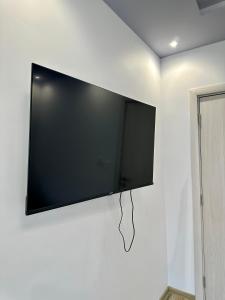 een flatscreen-tv aan een witte muur bij Central Vista Apartment by LMG in Sofia