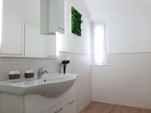 baño blanco con lavabo y ventana en Chrizia, en Novi Ligure