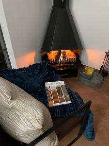 a living room with a fireplace and a book on a couch at City comfort self catering Windhoek in Windhoek