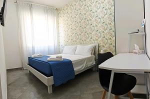 a small room with a bed and a table and a window at A casa di Alma in Terni