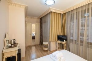 a hotel room with a bed and a desk and a television at Felicity Hotel İstanbul in Istanbul
