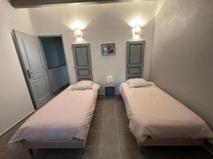 duas camas num quarto com duas luzes na parede em Clos Augusta 1 em Riez
