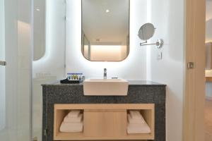 a bathroom with a sink and a mirror at Centre Point Pratunam in Bangkok