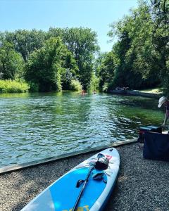 a blue kayak sitting on the shore of a river at Immaculate and Quiet Double Room - Great for Business and Travel Guests in Thorpe Saint Andrew