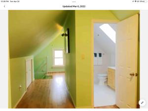 a bathroom with green walls and a toilet in it at Cozy 1-bedroom loft with falls view 4mins to falls in Niagara Falls