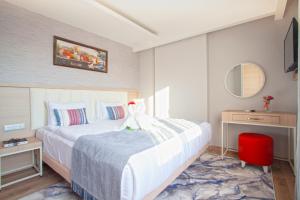 a bedroom with a large bed and a red chair at Old Town Point Hotel & Spa Antalya in Antalya