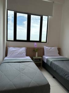 - 2 lits dans une chambre avec 2 fenêtres dans l'établissement myRumah Imperio Home , Alor Setar 3BR with Sky Infinity Pool, à Alor Setar