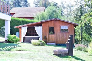 un pequeño cobertizo de madera en el patio trasero de una casa en Le Gîte du Chat Botté - Spa et Nature, en Hazelbourg