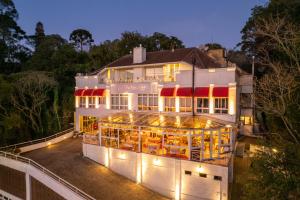 格拉馬杜的住宿－Le Boutique Hotel Gramado - Exclusivo para Casais，一座白色的大建筑,有红色遮阳篷