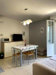 a living room with a dining room table and chairs at Maisonette cibeno in Carpi