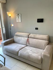 a white couch in a living room with a lamp at Maisonette cibeno in Carpi