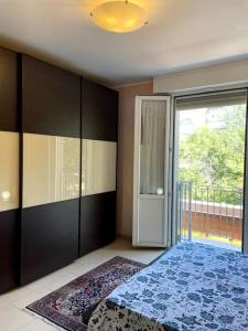 a bedroom with a bed and a large window at Maisonette cibeno in Carpi