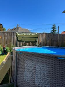 a swimming pool in a backyard with a green umbrella at Dom Frana Krala in Smrečany