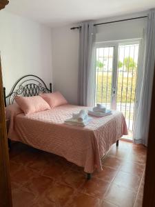 een slaapkamer met een bed met roze lakens en een raam bij Villa Jara 25 in Nerja