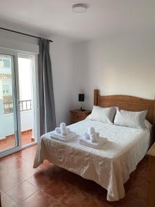een slaapkamer met een bed met twee handdoeken erop bij Villa Jara 25 in Nerja