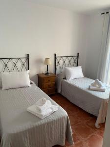 two beds in a room with towels on them at Villa Jara 25 in Nerja