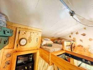 a bedroom with a bed and a clock in a room at Tiny House, WIFI,Hot tub,Secluded in Cosby