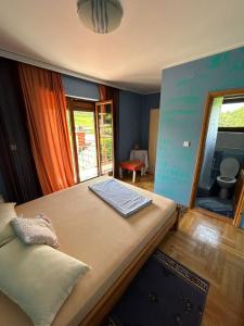 a bedroom with a large bed and a bathroom at Vila Dalmatinka in Gornja Toplica