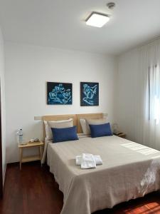 una camera da letto con un grande letto con cuscini blu di Guest House MJ a Póvoa de Varzim