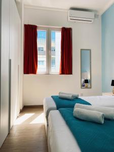 two beds in a room with red curtains at Miami Apartments in St. Julianʼs