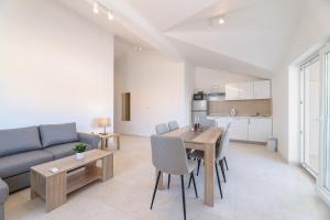 a living room with a couch and a table with chairs at Sea view by Moro in Malinska