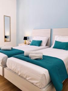 two beds in a bedroom with blue and white at Miami Apartments in St. Julianʼs