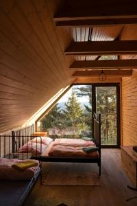 two beds in a room with a large window at Mountain Lodge Azzy, surrounded by Ultimate Peace! in Valašské Klobouky