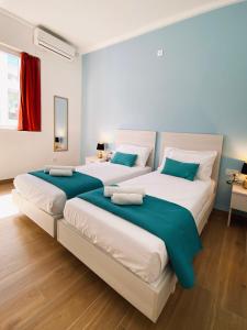 two large beds in a room with wood floors at Miami Apartments in St Julian's