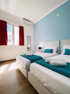 dwa łóżka w pokoju z czerwonym i niebieskim w obiekcie Miami Apartments w mieście St. Julian’s