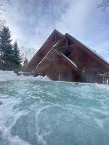 una casa de madera con nieve delante en Chalet Boreal Mont-Blanc, en Saint-Faustin