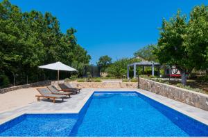 a swimming pool with two chairs and an umbrella at Holiday House Tone, Imotski-Drum-Makarska in Drum