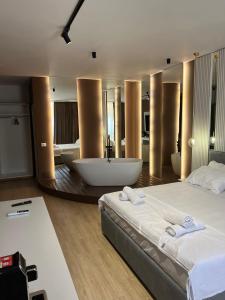 1 dormitorio con 1 cama grande y bañera en Capital Suites Center, en Tirana